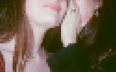 Pixelated close crop of a pale face and neck with pink lips and long brown hair