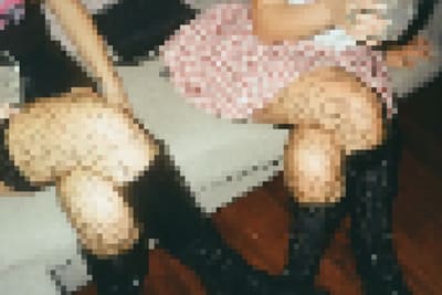 Pixelated top-down view of knees in sheer tights beside pink patterned fabric