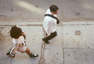 Two people crossing paths on the sidewalk, seen from directly above